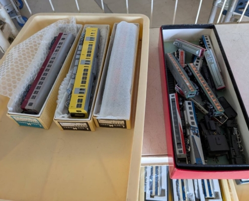 寒川町の空き家整理で見つかった鉄道模型。黄色い通勤型車両や特急型車両が箱に丁寧に収められている様子