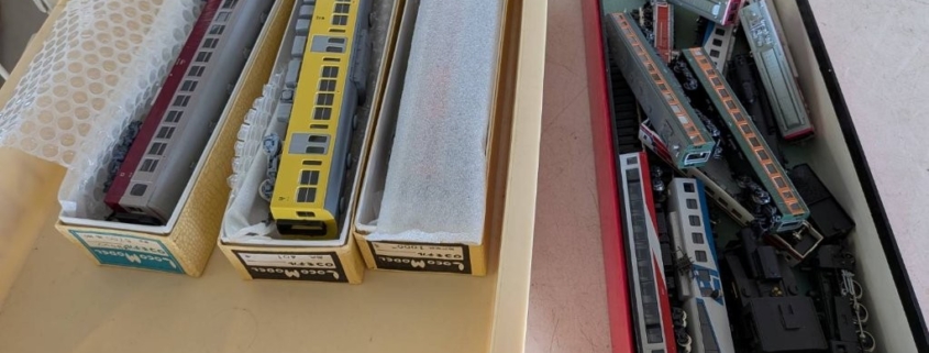 寒川町の空き家整理で見つかった鉄道模型。黄色い通勤型車両や特急型車両が箱に丁寧に収められている様子