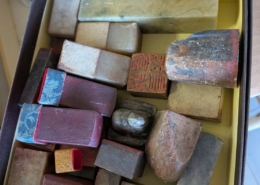 神奈川県川崎市幸区の実家建て替えに伴う片付け中に見つかった、中国印材（篆刻用石材）一式。未刻字の印材から使用済みの刻字印まで、大小さまざまな書道・篆刻用印材が箱にまとめて保管されている様子。