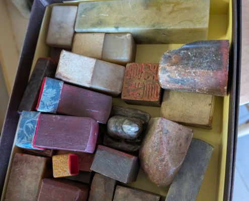 神奈川県川崎市幸区の実家建て替えに伴う片付け中に見つかった、中国印材（篆刻用石材）一式。未刻字の印材から使用済みの刻字印まで、大小さまざまな書道・篆刻用印材が箱にまとめて保管されている様子。