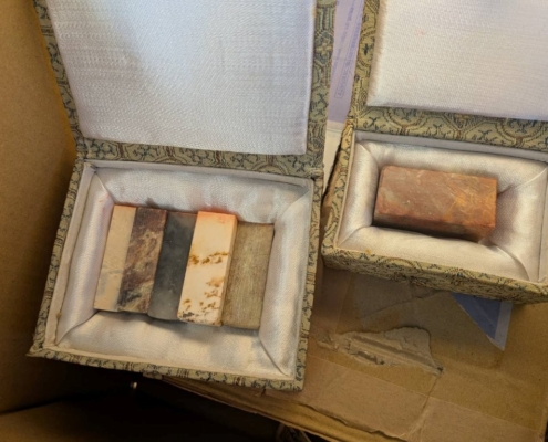 実家の片付け中に見つかった、箱に収められた中国の篆刻用印材（中国印材）。色味や石質の異なる印材が複数本揃った状態。