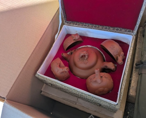 神奈川県川崎市中原区の実家解体に伴う片付け中に見つかった、中国工夫茶用の朱泥煎茶道具一式を、箱を開けて全体構成が分かる状態で撮影した写真。