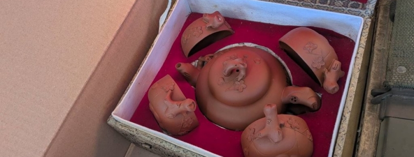 神奈川県川崎市中原区の実家解体に伴う片付け中に見つかった、中国工夫茶用の朱泥煎茶道具一式を、箱を開けて全体構成が分かる状態で撮影した写真。